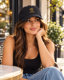 Woman wearing black King Eddie signature crest dad hat at an outdoor café.