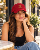 Woman wearing cranberry King Eddie signature crest dad hat at an outdoor café